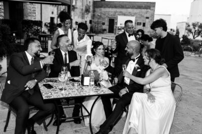 foto spontanea di sposi seduti con amici